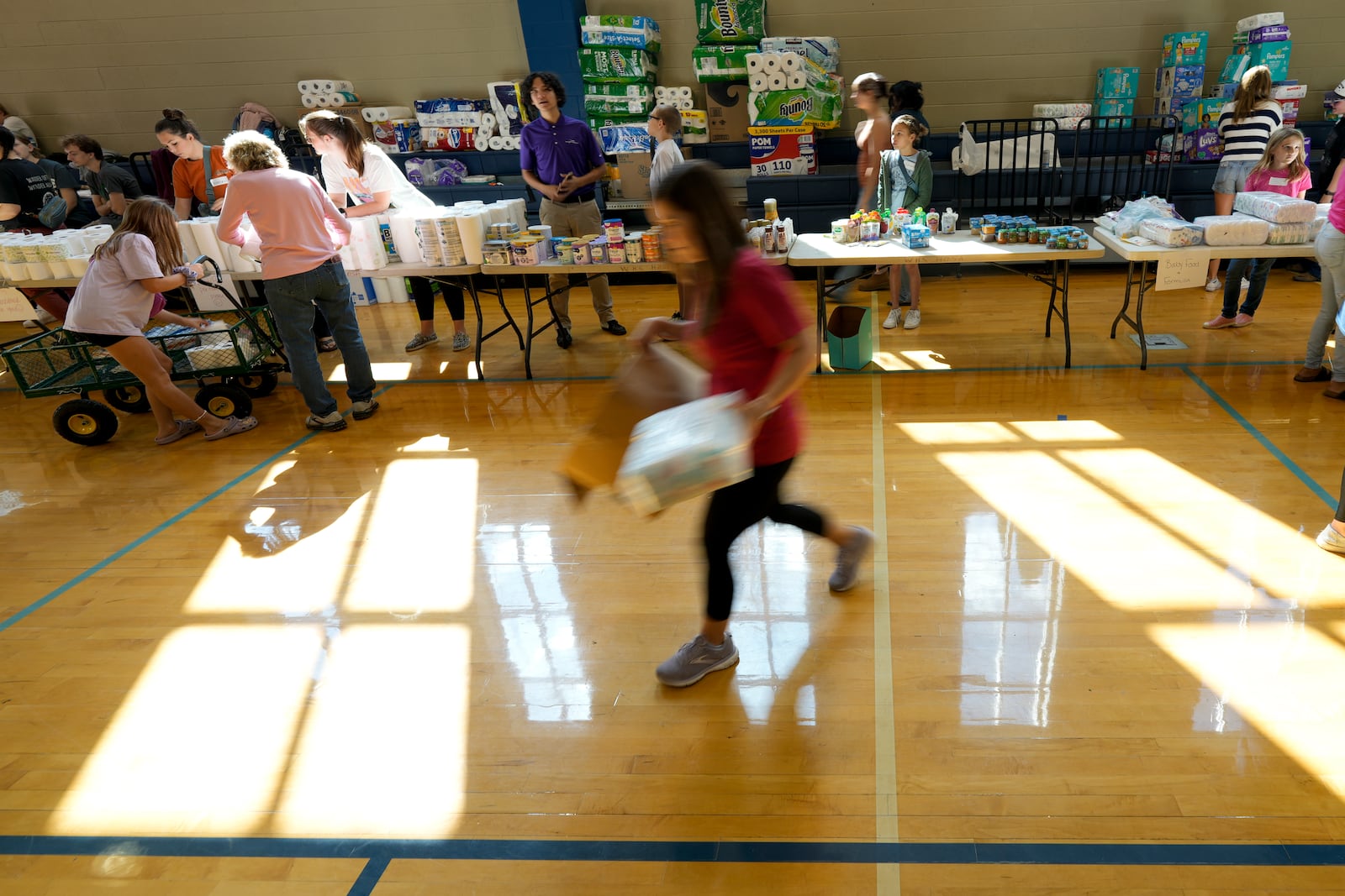 A volunteer unloads supplies at Watauga High School on Thursday, Oct. 3, 2024, in Boone, N.C. in the aftermath of hurricane Helene. In the final weeks of the presidential election, people in North Carolina and Georgia, influential swing states, are dealing with more immediate concerns: recovering from Hurricane Helene. (AP Photo/Chris Carlson)