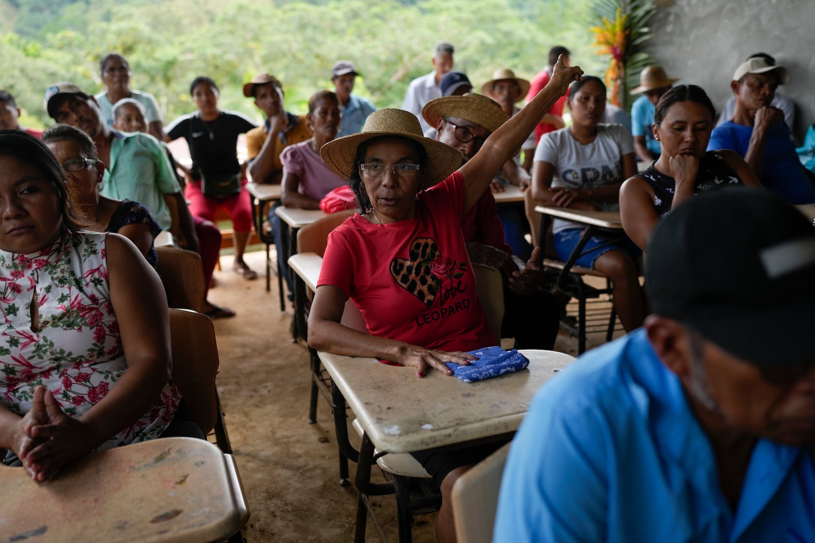 Jeronima Figueroa raises her hand during a meeting with Panama Canal representatives about a proposed project that would dam the Indio River and limit access in her community of El Jobo, Panama, Saturday, Aug. 31, 2024. The project aims to secure the water needed to ensure the canal’s uninterrupted operation. (AP Photo/Matias Delacroix)