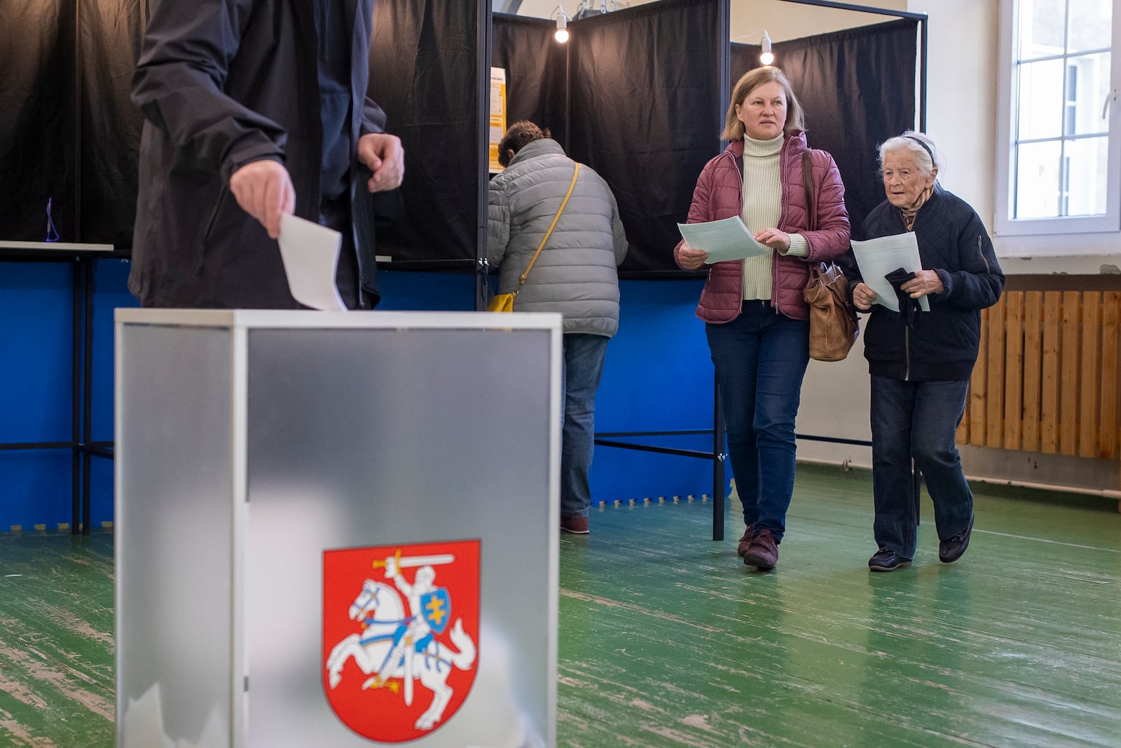 Residents cast their ballots at a polling station during the first round of voting in presidential elections in Vilnius, Lithuania, Sunday, Oct. 13, 2024. (AP Photo/Mindaugas Kulbis)