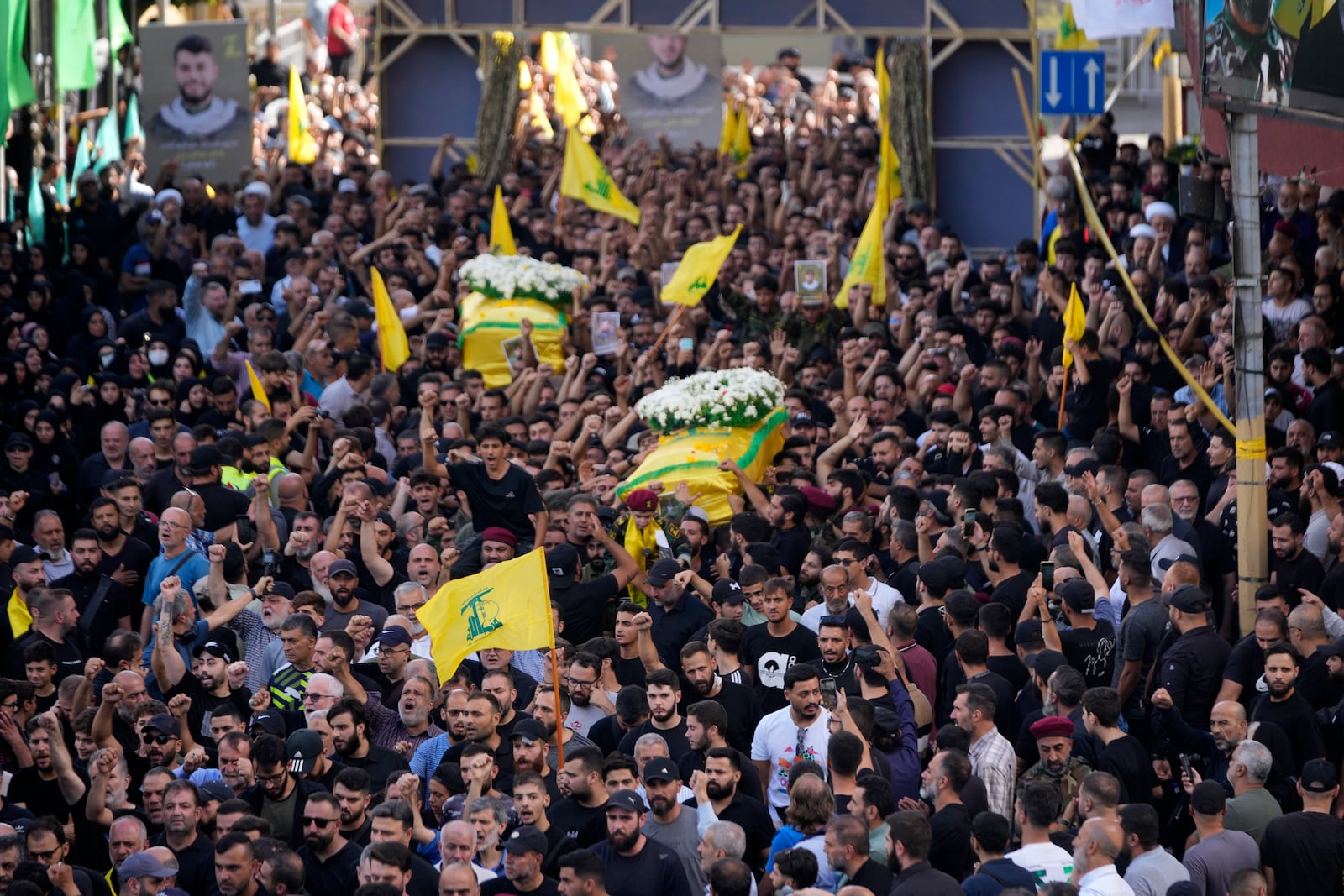 Hezbollah members carry the coffins of two of their comrades who were killed on Wednesday when a handheld device exploded, during a funeral procession in the southern suburbs of Beirut, Thursday, Sept. 19, 2024. (AP Photo/Hussein Malla)