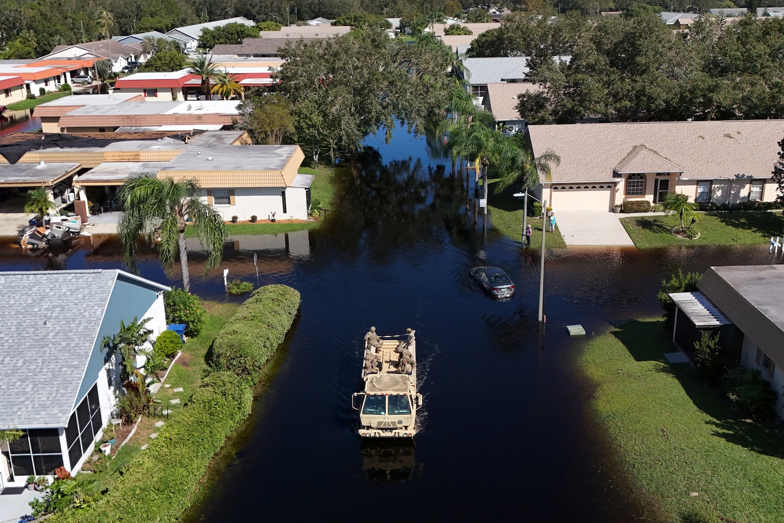 A truck from the Florida National Guard goes out to help residents trapped in their homes as waters rise after Hurricane Milton caused the Anclote River to flood, Friday, Oct. 12, 2024, in New Port Richey, Fla. (AP Photo/Mike Carlson)