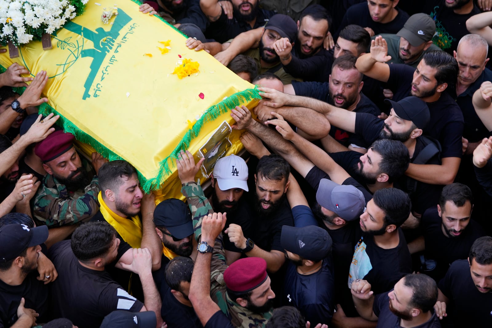 Hezbollah members carry the coffin of their comrade who was killed on Wednesday when a handheld device exploded, during a funeral procession in the southern suburbs of Beirut, Thursday, Sept. 19, 2024. (AP Photo/Hussein Malla)