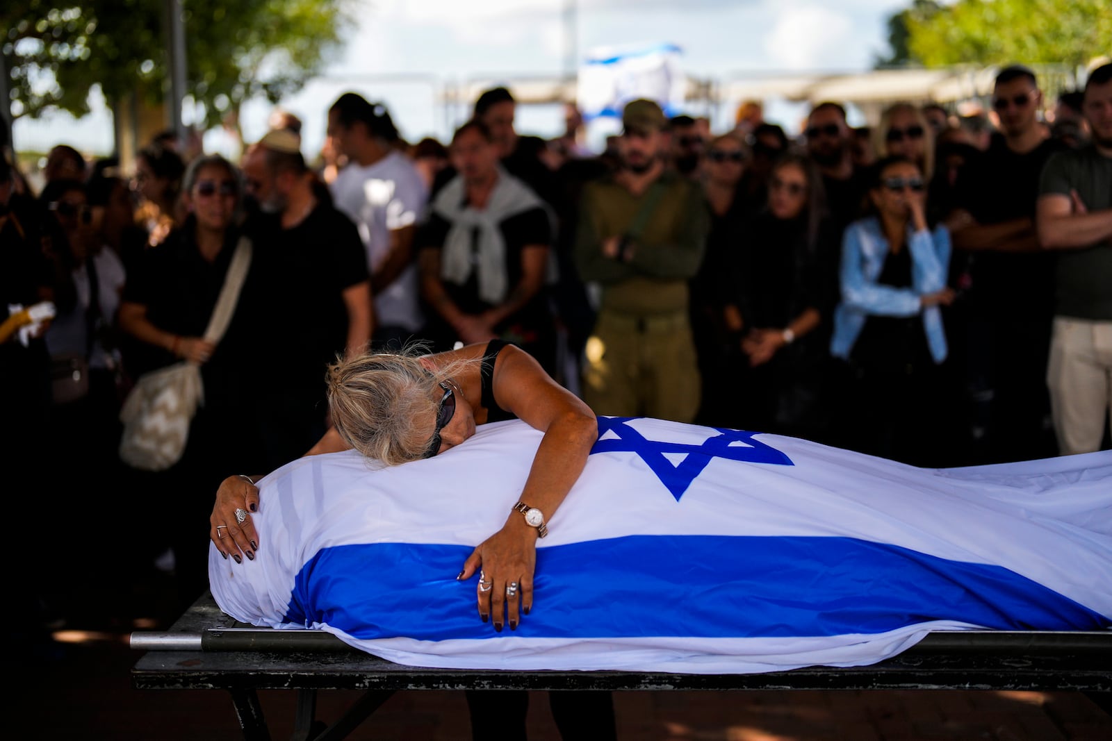 Antonio Macías' mother cries over her son's body covered with the Israeli flag at Pardes Haim cemetery in Kfar Saba, near Tel Aviv, Israel, Sunday, Oct. 15, 2023. (AP Photo/Francisco Seco)