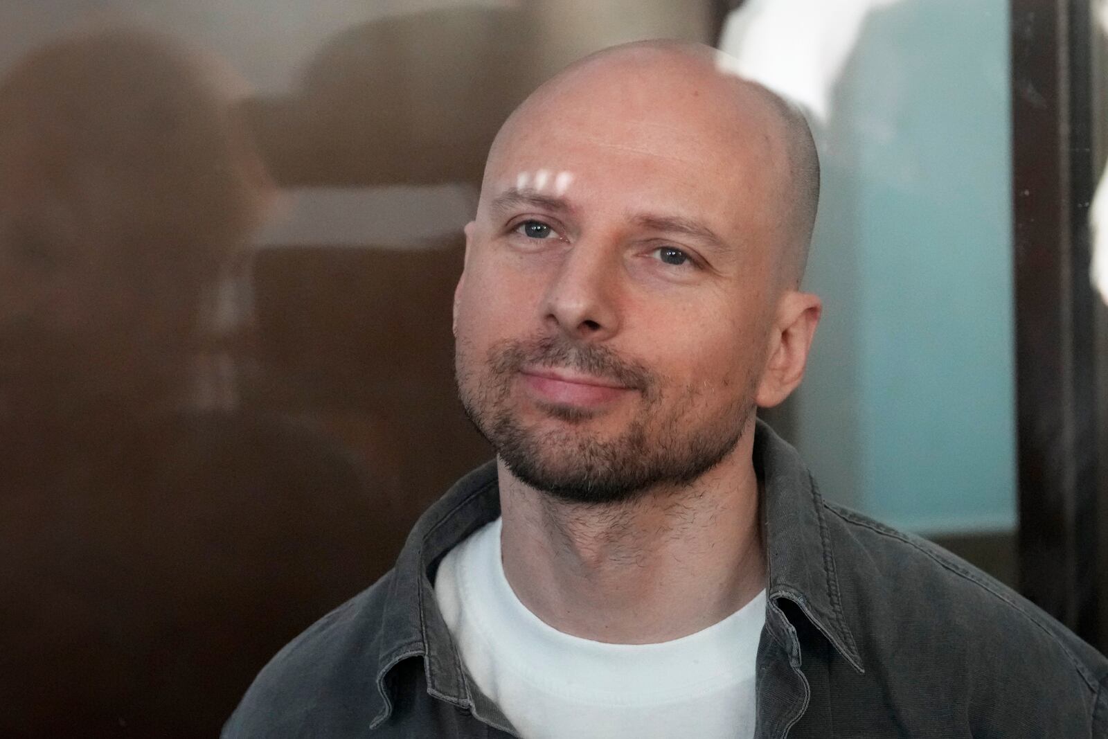 Russian journalist Sergey Karelin accused of working for a group founded by the late Russian opposition politician Alexei Navalny, stands in a defendant's cage of the Nagatinsky District Court in Moscow, Russia, on Wednesday, Oct. 2, 2024. (AP Photo)