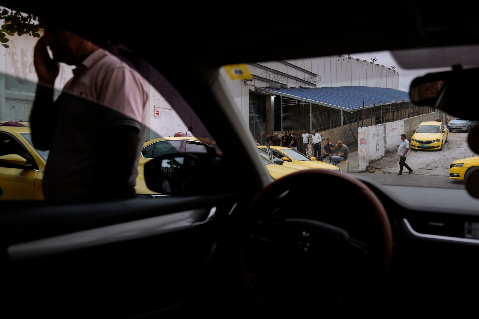 Palestinian taxi drivers gather in front of the Israeli army checkpoint between the West Bank city of Bethlehem and Jerusalem, Tuesday, Sept. 17, 2024. (AP Photo/Mahmoud Illean)