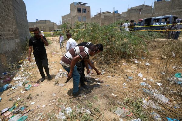 Pakistani investigators examine at a cordoned off site, where Pakistan's air defense system shot down a suspected Indian drone, in Karachi, Pakistan, Thursday, May 8, 2025. (AP Photo/Fareed Khan)