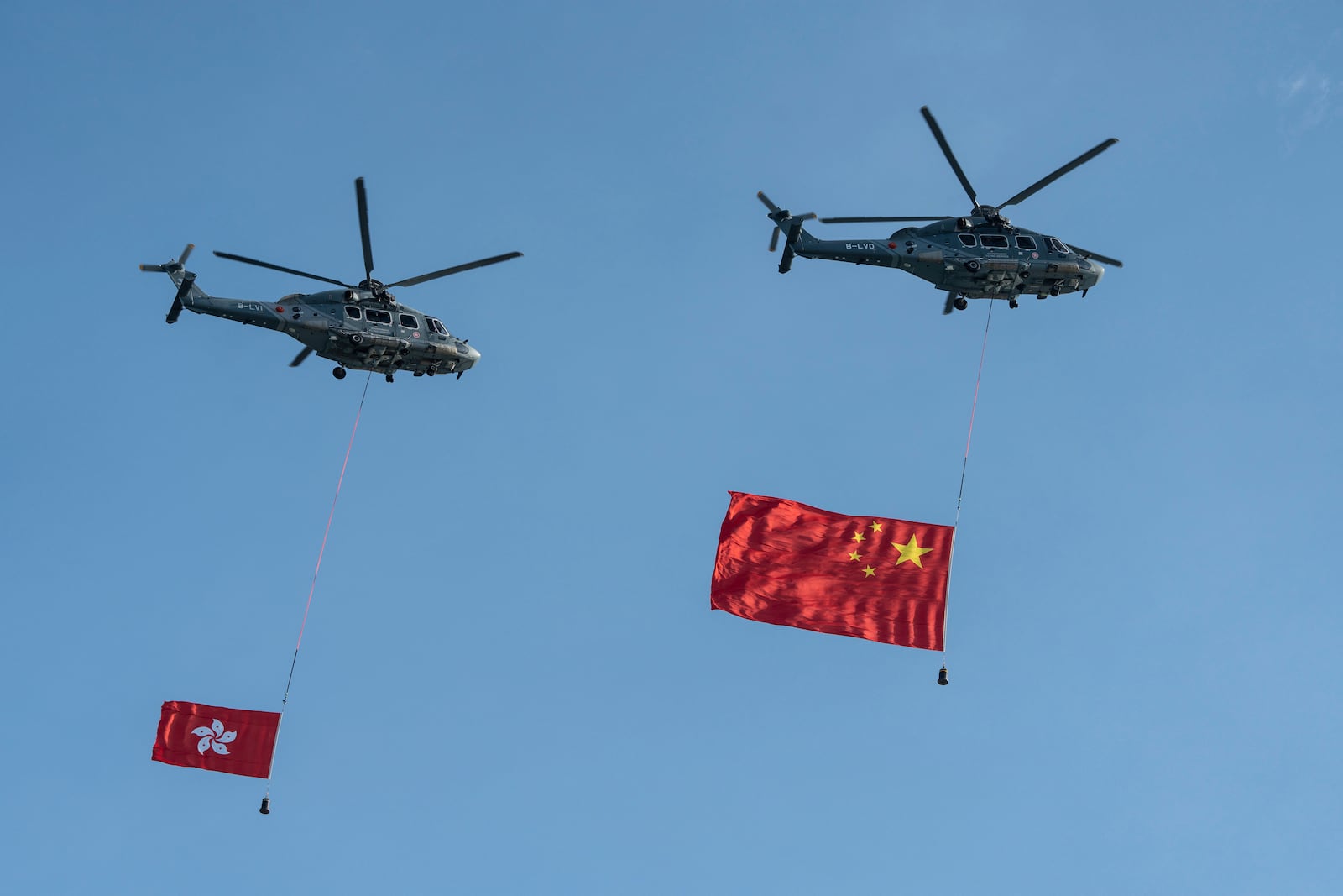 Helicopters carry China and Hong Kong flags during a flag raising ceremony for the celebration of the 75th National Day of the People's Republic of China in Hong Kong, Tuesday, Oct. 1, 2024. (AP Photo/Chan Long Hei)