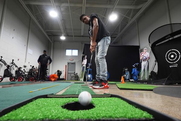 Jacento White, 16, a junior golfer at Renaissance High School practices putting in Detroit, Thursday, Feb. 27, 2025. (AP Photo/Paul Sancya)