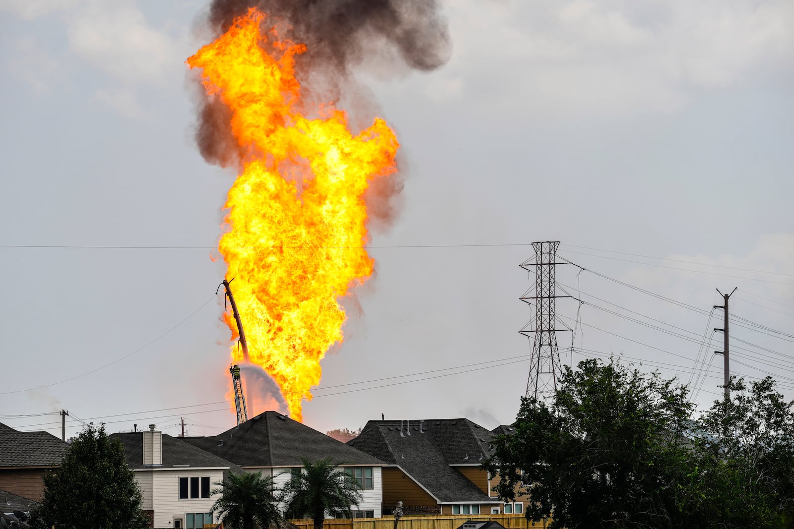 A firefighter directs a line of water around a fire on a pipeline carrying liquified natural gas near Spencer Highway and Summerton on Monday, Sept. 16, 2024, in La Porte, Texas. (Brett Coomer/Houston Chronicle via AP)