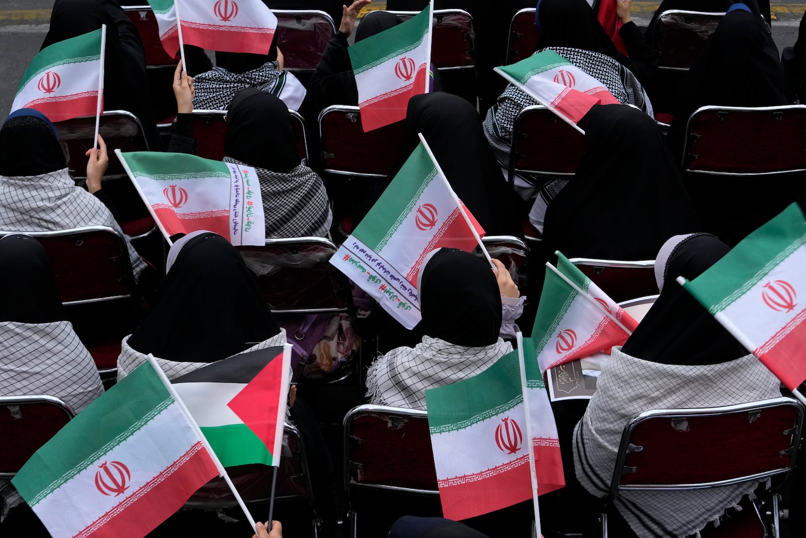 Demonstrators wave Iranian and Palestinian flags in an annual rally in front of the former U.S. Embassy in Tehran, Iran, Sunday, Nov. 3, 2024, marking the 45th anniversary of Iranian students' takeover of the embassy, starting a hostage crisis. (AP Photo/Vahid Salemi)