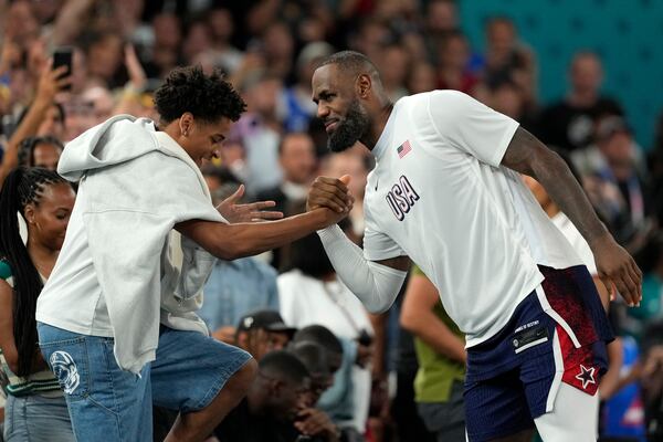 FILE - Kiyan Anthony, left, son of Carmelo Anthony, greets United States' LeBron James after the United States defeated Brazil in a men's basketball game at the 2024 Summer Olympics, Aug. 6, 2024, in Paris, France. (AP Photo/Michael Conroy, File)