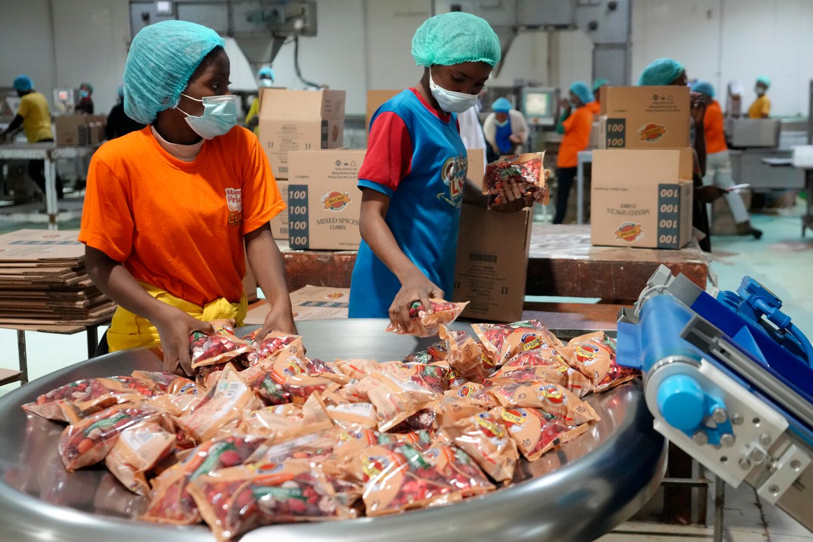 Workers collect bouillon cubes packages at the Sweet Nutrition factory in Otta, Nigeria, Thursday, Sept. 12, 2024. (AP Photo/Sunday Alamba)