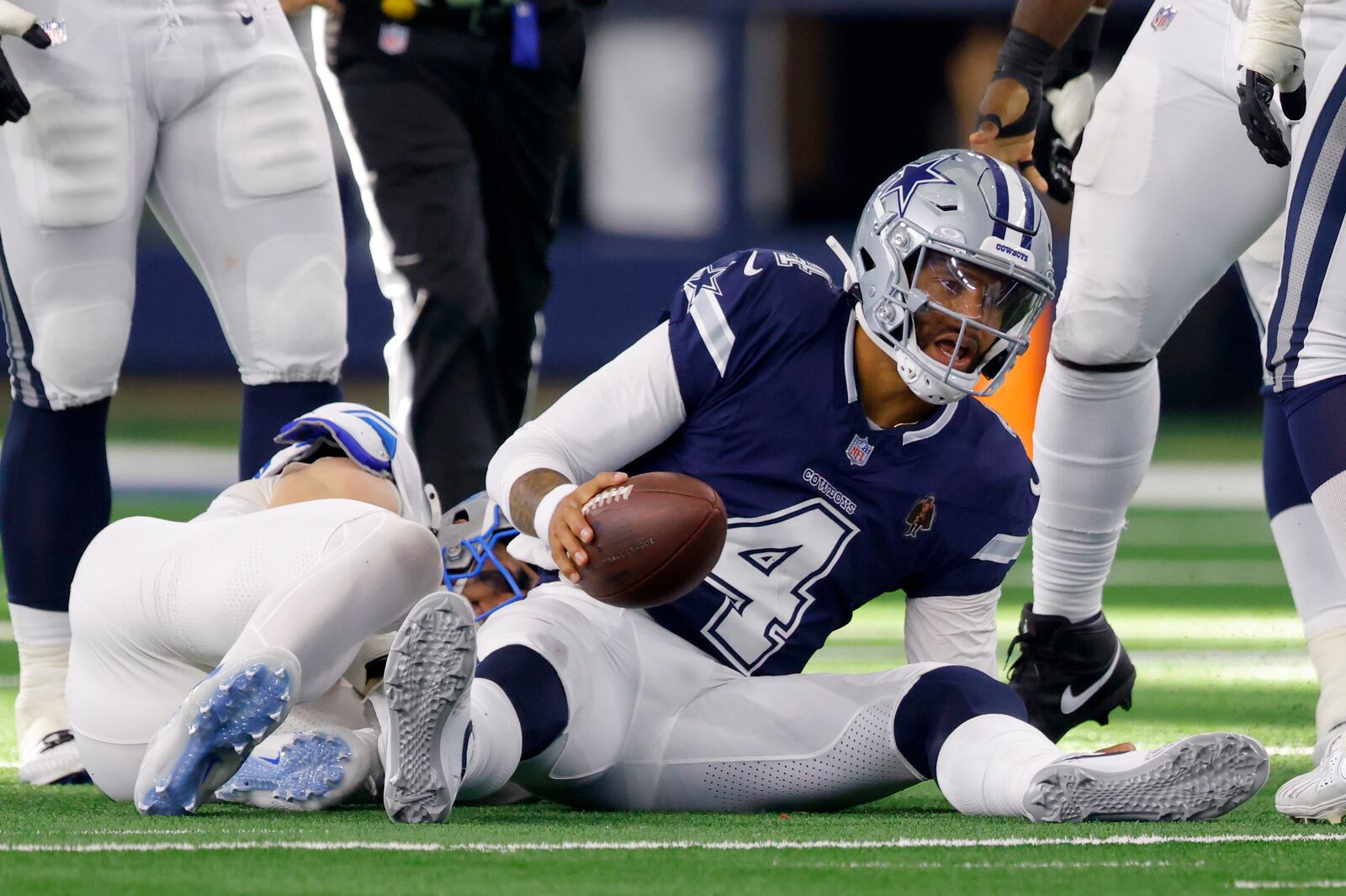 Dallas Cowboys quarterback Dak Prescott (4) recovers from being sacked by Detroit Lions defensive end Aidan Hutchinson, left, in the second half of an NFL football game in Arlington, Texas, Sunday, Oct. 13, 2024. (AP Photo/Gareth Patterson)