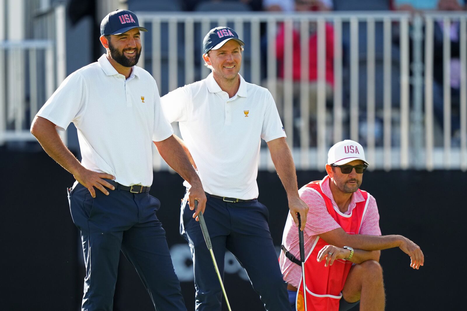 United States team members Scottie Scheffler, left, and Russell Henley, center, laugh on the 13th hole during their first-round four-ball match at the Presidents Cup golf tournament at the Royal Montreal Golf Club in Montreal, Thursday, Sept. 26, 2024. (Nathan Denette/The Canadian Press via AP)