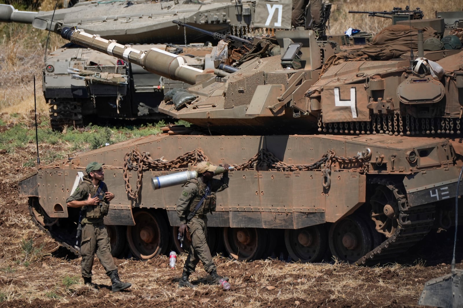 An Israeli soldier carries a shell next to a tank in northern Israel on Friday, Sept. 27, 2024. (AP Photo/Baz Ratner)