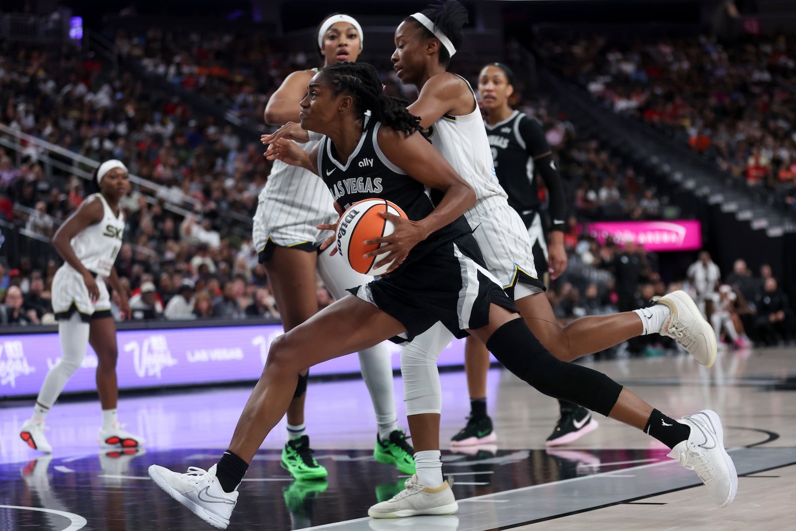 Las Vegas Aces guard Tiffany Hayes drives toward the hoop against Chicago Sky forward Angel Reese, back left, and guard Lindsay Allen, right, during the second half of an WNBA basketball game, Tuesday, Sept. 3, 2024, in Las Vegas. L (Ellen Schmidt/Las Vegas Sun via AP)