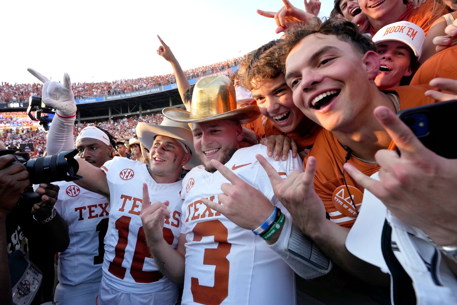 Texas quarterback Quinn Ewers (3) celebrates with teammates and fans after the teams win against Oklahoma in an NCAA college football game in Dallas, Saturday, Oct. 12, 2024. (AP Photo/Jeffrey McWhorter)