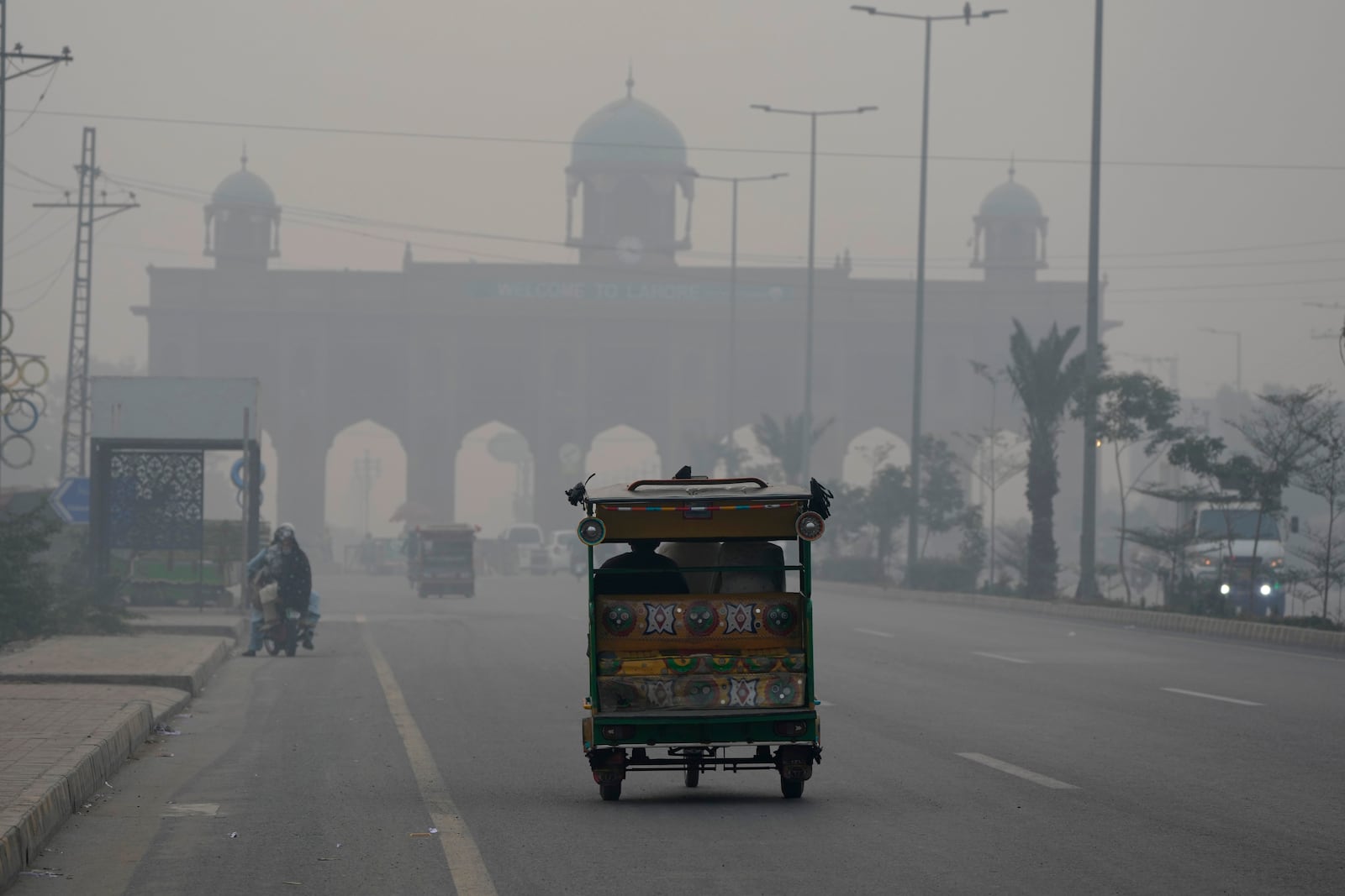 A motorcycle-rickshaw drives on a road as smog envelops the areas of Lahore, Pakistan, Wednesday, Nov. 6, 2024. (AP Photo/K.M. Chaudary)