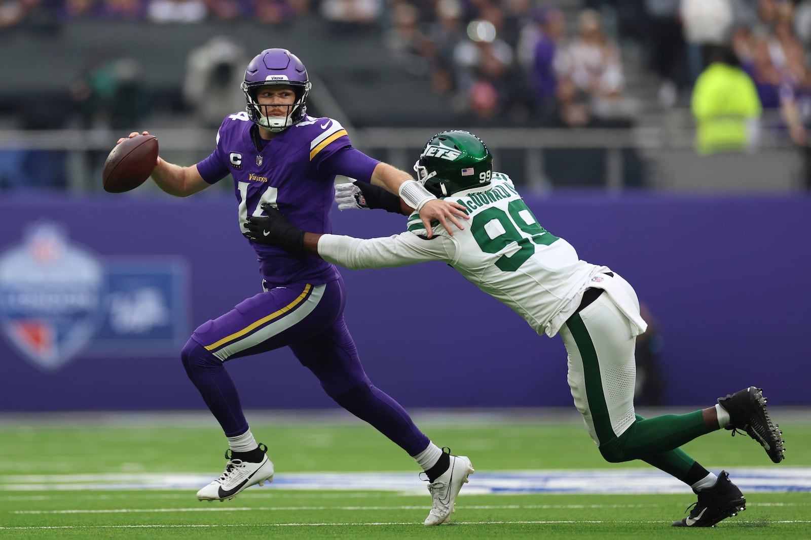 New York Jets' Will McDonald IV, right, sacks Minnesota Vikings quarterback Sam Darnold during the first half of an NFL football game, Sunday, Oct. 6, 2024, at the Tottenham Hotspur stadium in London. (AP Photo/Ian Walton)