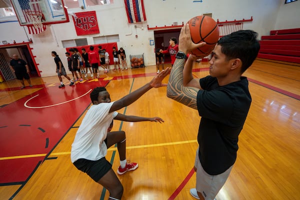 TJ Rickard, right, Lahainaluna High School boys basketball coach, practices with players at Lahainaluna High School, Monday, Nov. 18, 2024, in Lahaina, Hawaii. (AP Photo/Mengshin Lin)