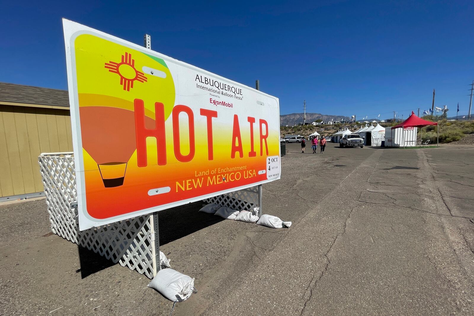 A sign mimicking a giant New Mexico license plate welcomes visitors to the annual Albuquerque International Balloon Fiesta at Balloon Fiesta Park in Albuquerque, N.M., on Thursday, Oct. 3, 2024. Above average temperatures are expected this year as hundreds of colorful hot air balloons take to the skies beginning Saturday, Oct. 5, 2024. (AP Photo/Susan Montoya Bryan)