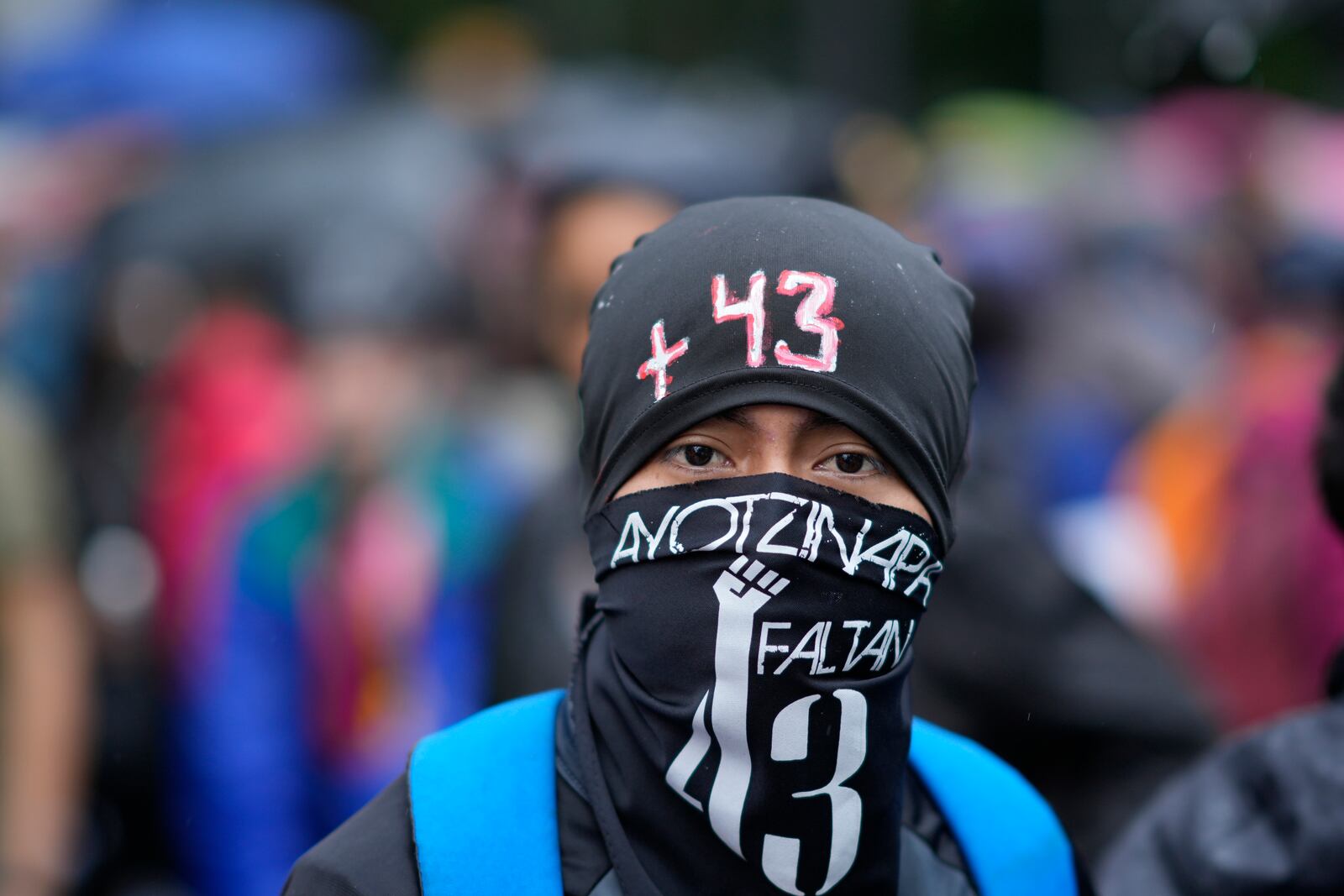 A masked youth takes part in a demonstration marking the 10-year anniversary of the disappearance of 43 students from an Ayotzinapa rural teacher's college, in Mexico City, Thursday, Sept. 26, 2024. (AP Photo/Fernando Llano)