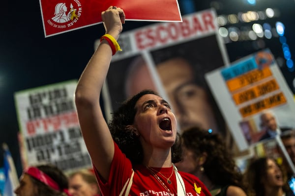 A woman shouts slogans during a protest against Prime Minister Benjamin Netanyahu's government and call for the release of hostages held in the Gaza Strip by the Hamas militant group, in Tel Aviv, Israel, Saturday, Nov. 16, 2024. (AP Photo/Francisco Seco)