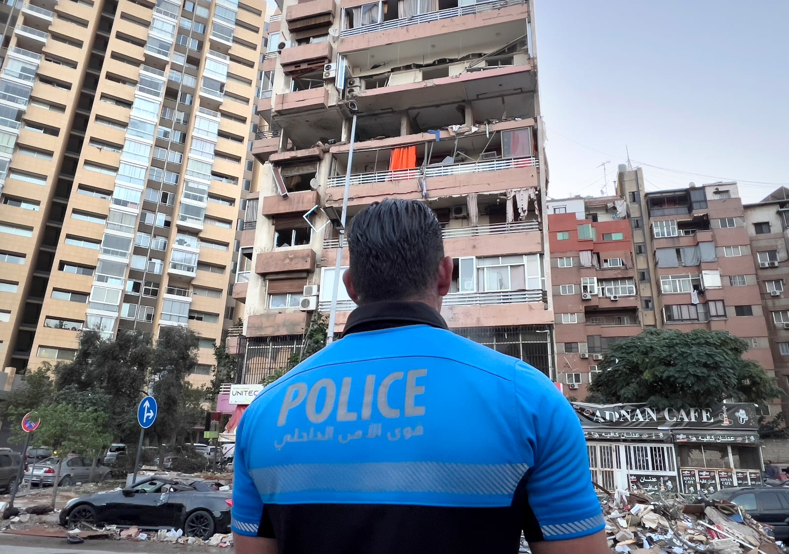 A Lebanese policeman looks at damaged apartments that were hit by Israeli strike early Monday, Sept. 30, 2024. (AP Photo/Hussein Malla)