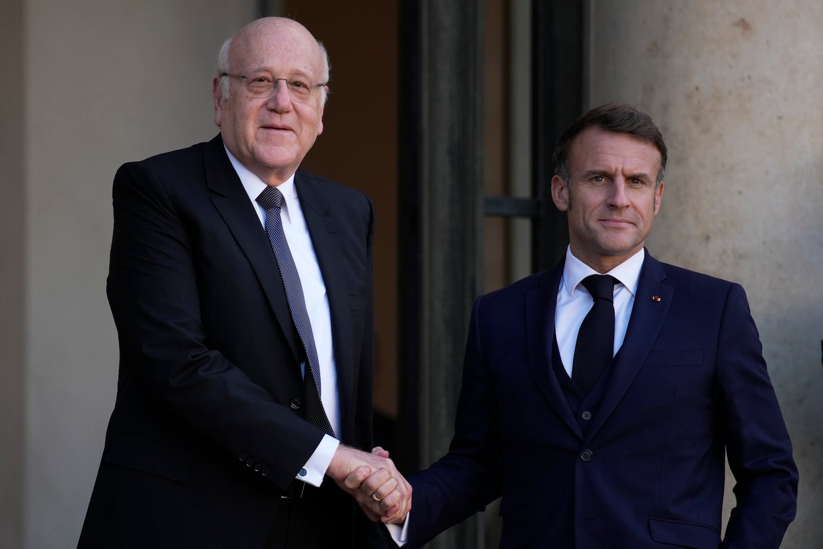 French President Emmanuel Macron welcomes Lebanese caretaker Prime Minister Najib Mikati, left, Wednesday, Oct. 23, 2024 at the Elysee Palace in Paris. (AP Photo/Louise Delmotte)