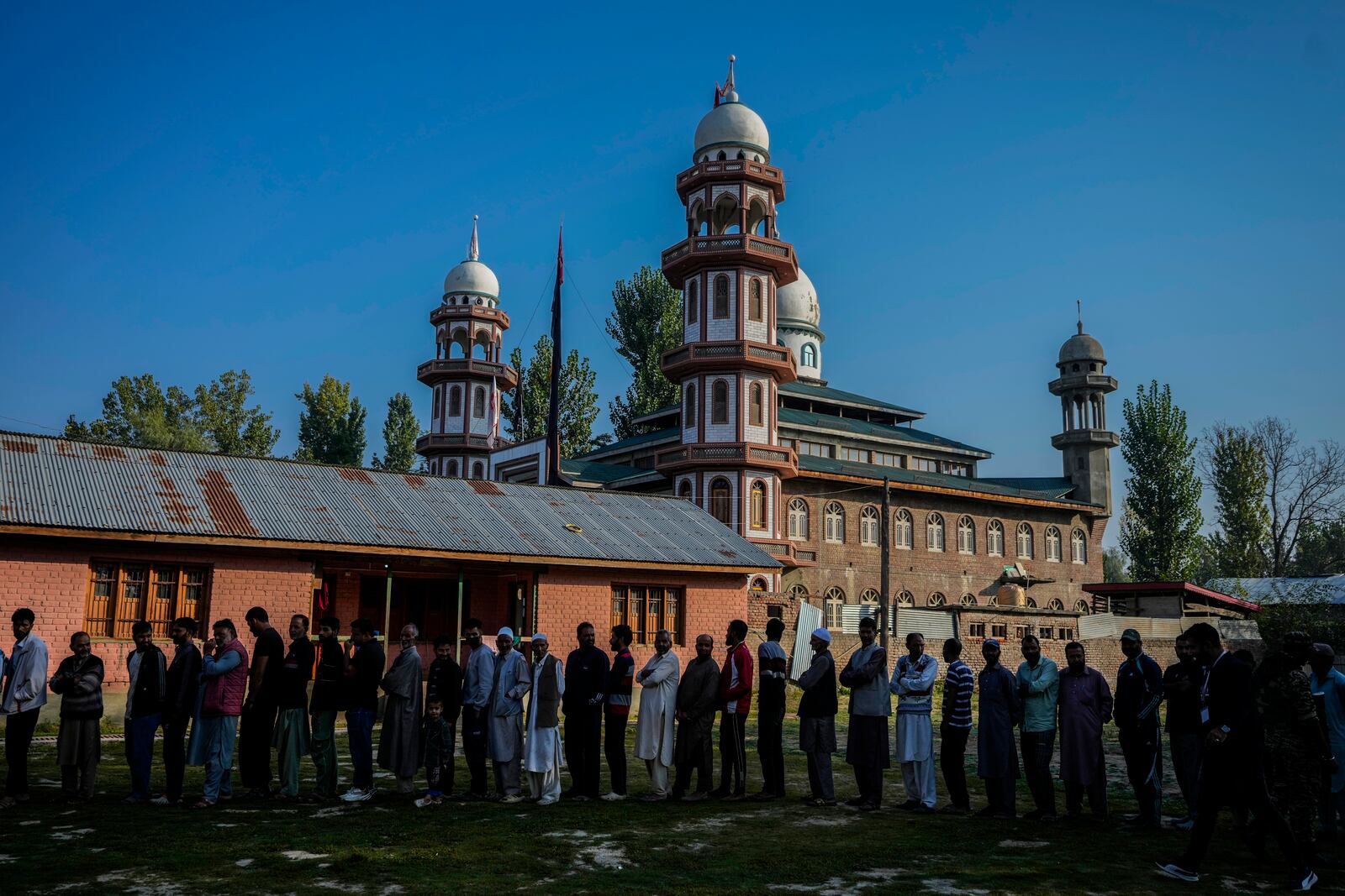 Kashmiris queue up at a polling booth to cast their vote during the final phase of an election to choose a local government in Indian-controlled Kashmir, north of Srinagar, Tuesday, Oct.1, 2024. (AP Photo/Mukhtar Khan)