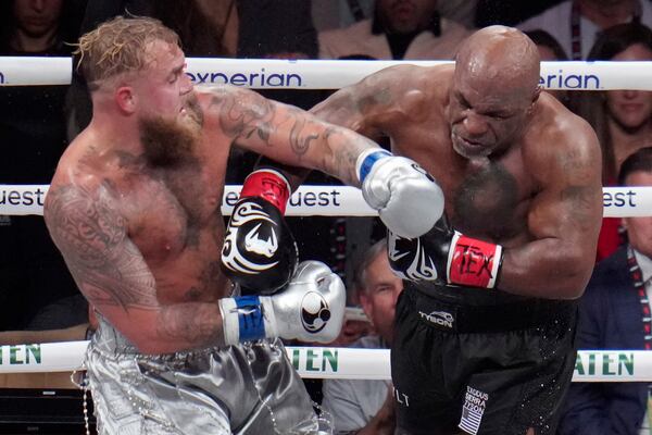 Jake Paul, left, fights Mike Tyson during their heavyweight boxing match, Friday, Nov. 15, 2024, in Arlington, Texas. (AP Photo/Julio Cortez)