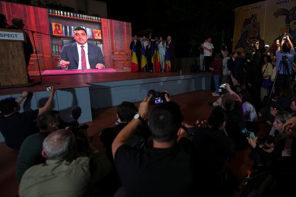 Presidential candidate George Simion is shown on a screen at the meeting of his supporters after polls closed for the first round of the country's presidential election redo in Bucharest, Romania, Sunday, May 4, 2025. (AP Photo/Andreea Alexandru)