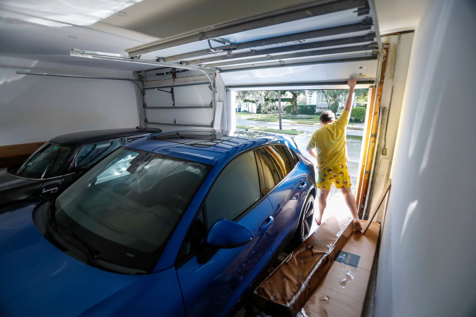 Max Ceratti, 19, lifts up the garage door to examine the damage done to his car from Hurricane Helene at his home around the Sunset Park neighborhood on Friday, Sept. 27, 2024, in Tampa, Fla. (Jefferee Woo/Tampa Bay Times via AP)