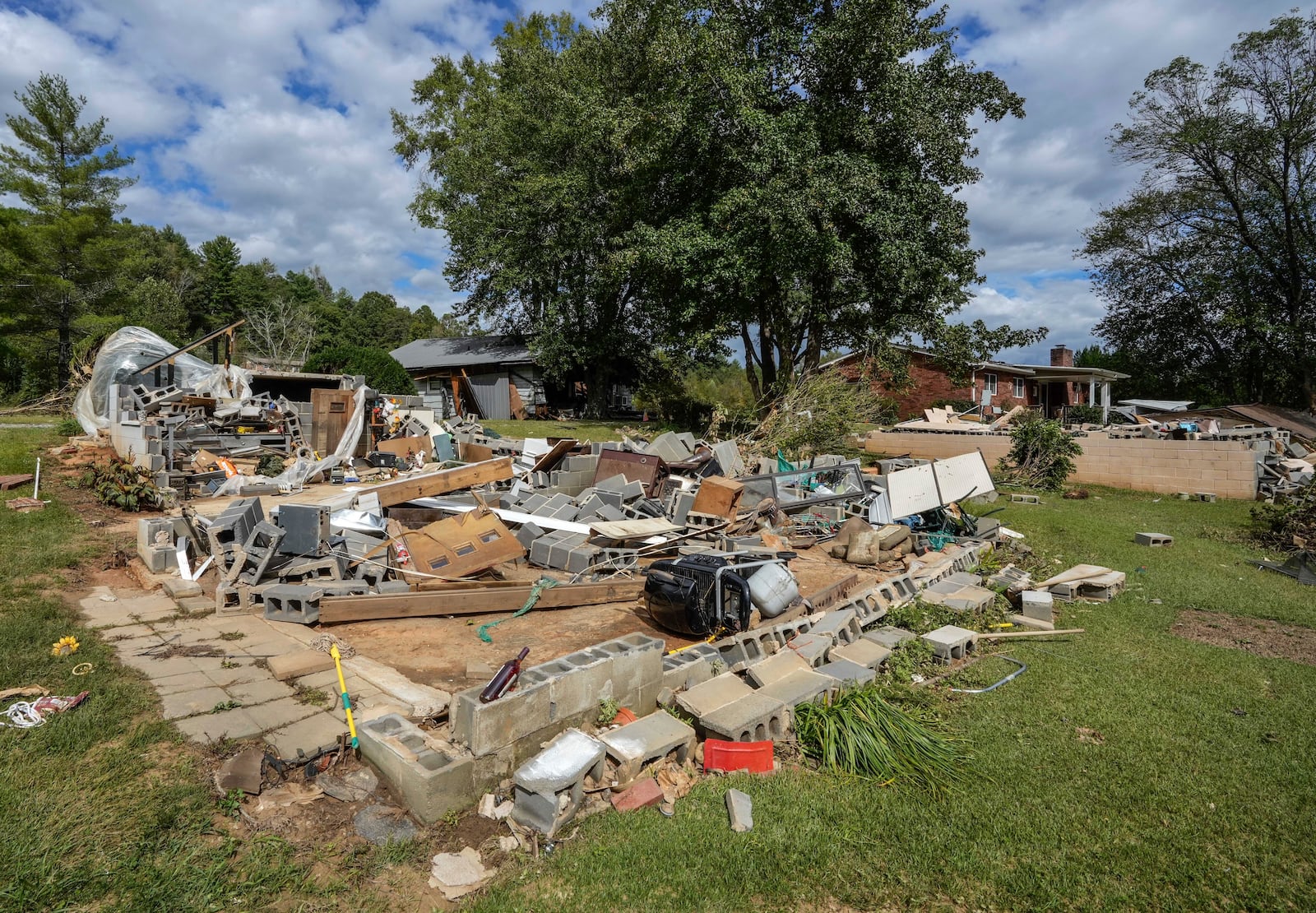 All that is left is the foundation of one of the White family homes, destroyed by Hurricane Helene, Tuesday, Oct. 1, 2024 in Morganton, N.C. The adjacent Catawba River flooded due to the torrential rains destroying the seven of family's nine homes on the property. (AP Photo/Kathy Kmonicek)