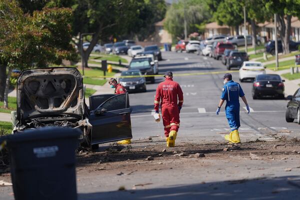 Authorities work the scene where a small plane crashed into a San Diego neighborhood, setting several homes on fire and forcing evacuations along several blocks early Thursday, May 22, 2025. (AP Photo/Gregory Bull)