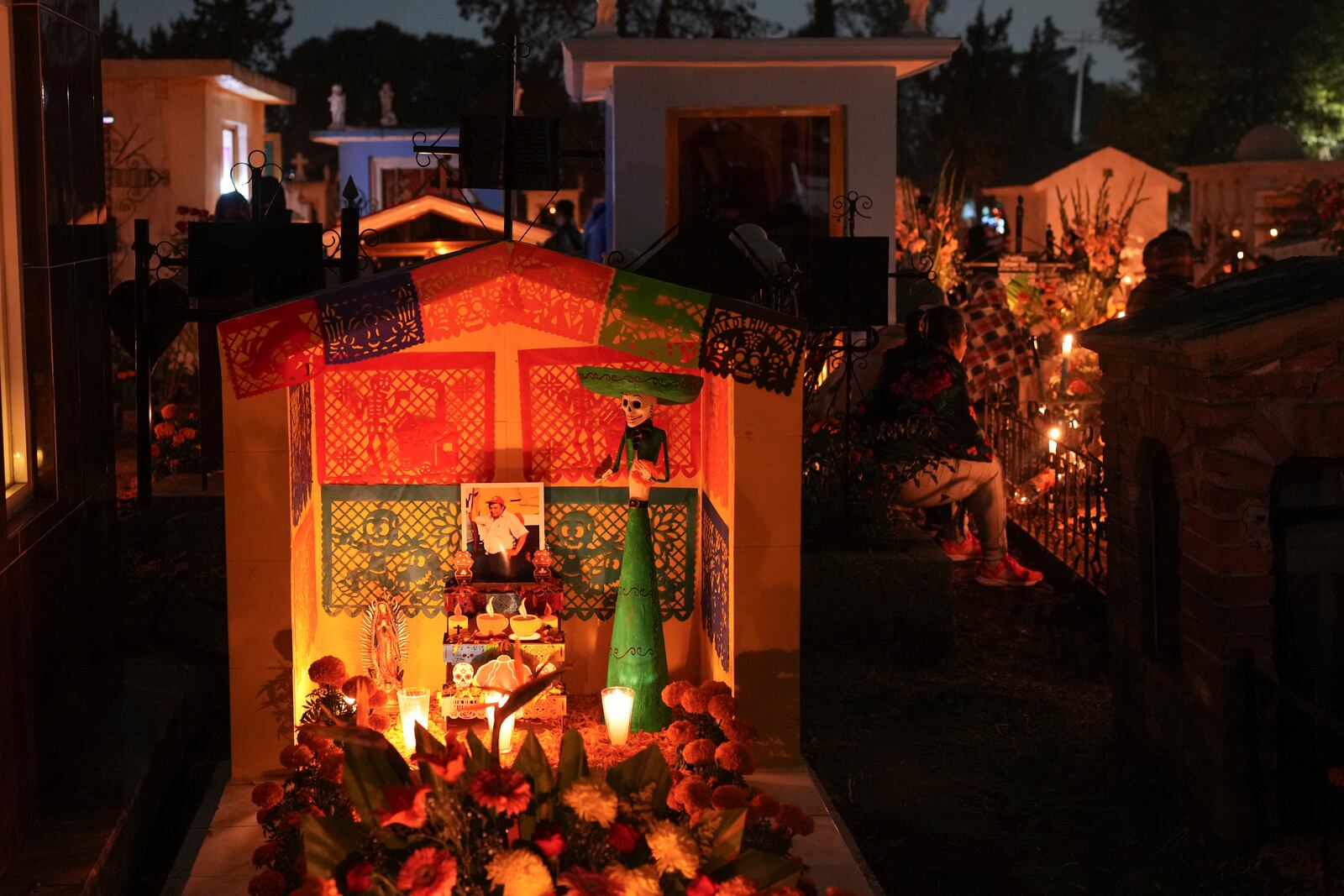 A tomb is decorated with a Catrina sculpture and cempasúchil flowers or marigolds, celebrating Day of the Dead, at the San Gregorio Atlapulco cemetery on the outskirts of Mexico City, Friday, Nov. 1, 2024. (AP Photo/Moises Castillo)