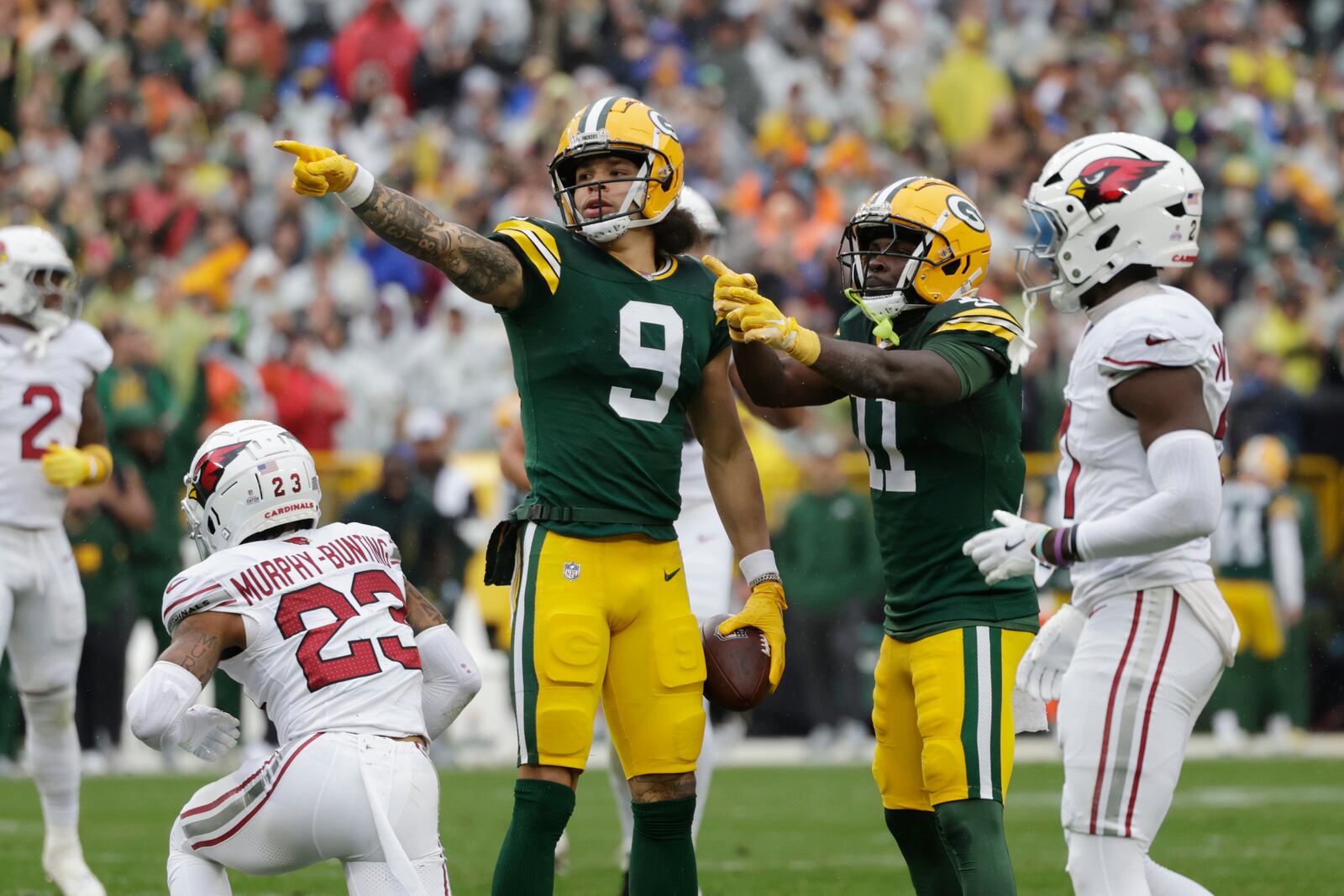 Green Bay Packers wide receiver Christian Watson (9) signals a first down after a reception during the first half of an NFL football game against the Arizona Cardinals, Sunday, Oct. 13, 2024, in Green Bay. (AP Photo/Matt Ludtke)