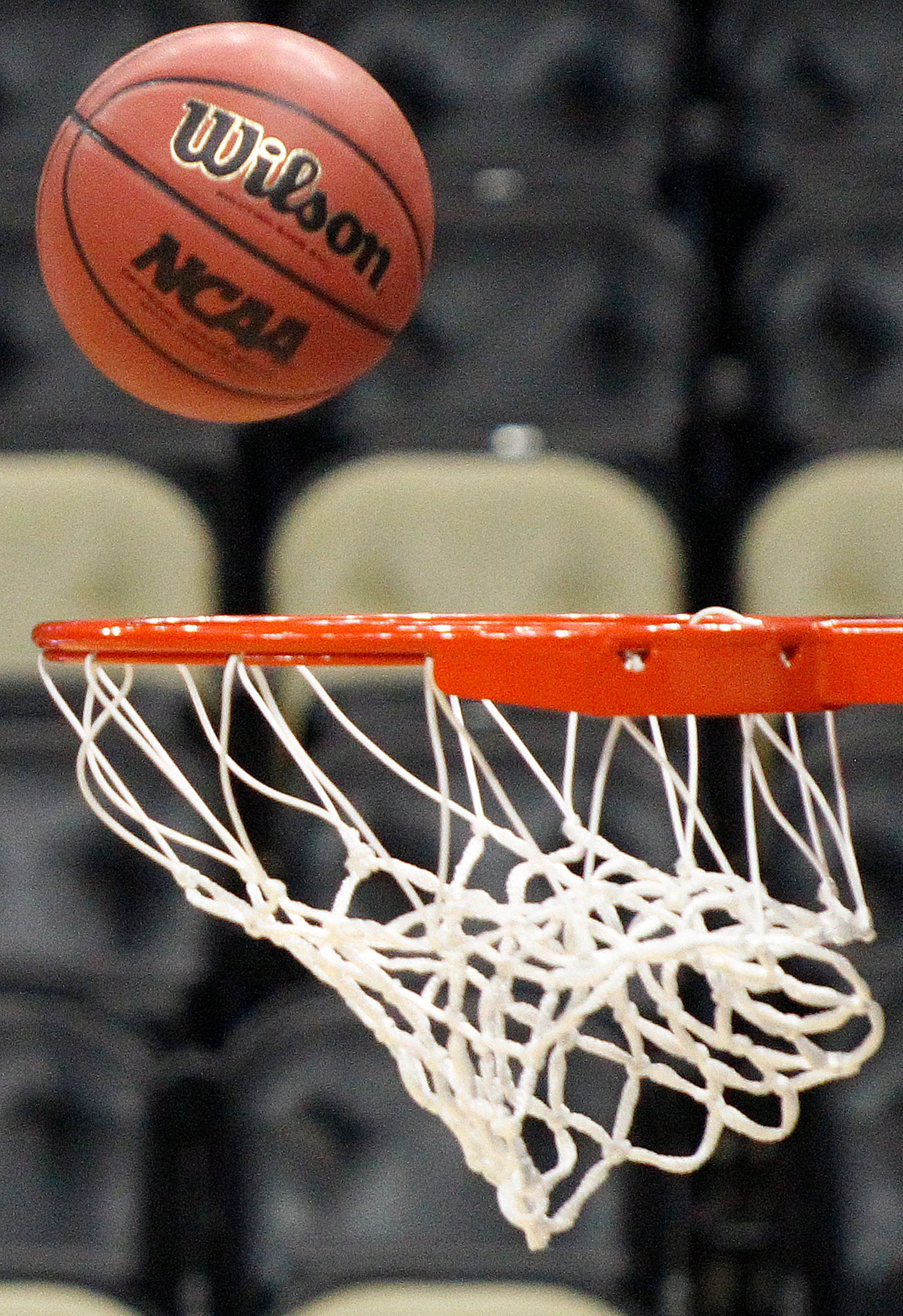 FILE - A basketball with an NCAA logo is shot at the basket during Gonzaga's basketball practice in Pittsburgh, March 14, 2012. (AP Photo/Keith Srakocic, file)