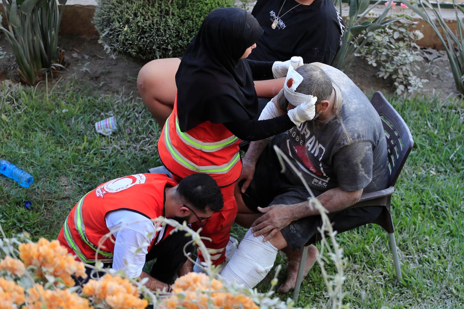 Paramedics treats a man who was injured after an Israeli airstrike hit two adjacent buildings east of the southern port city of Sidon, Lebanon, Sunday, Sept. 29, 2024. (AP Photo/Mohammed Zaatari)