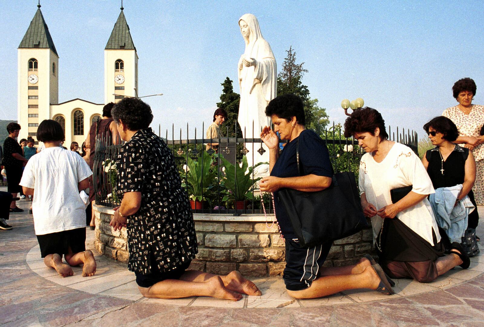 FILE - Bosnian Roman Catholic women pray on the occasion of the feast of the Assumption in Medjugorje, some 120 kilometers (75 miles) south of the Bosnian capital, Sarajevo, on Aug. 15, 2000. (AP Photo/Hidajet Delic, File)