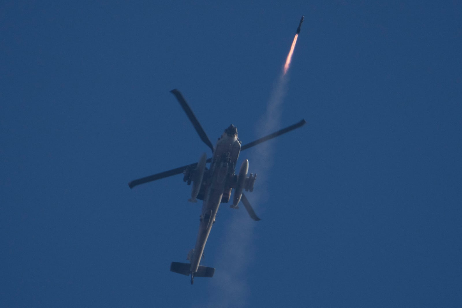 An Israeli Apache helicopter fires a missile towards southern Lebanon as seen from northern Israel, Friday, Oct. 4, 2024. (AP Photo/Leo Correa)