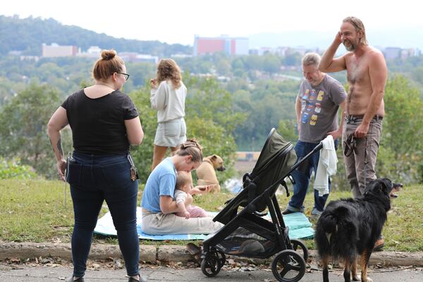 FILE - People gather on a hill in Asheville, North Carolina, where they can find a little cellphone service on Monday, Sept. 30, 2024. (AP Photo/Jeffrey Collins, File)