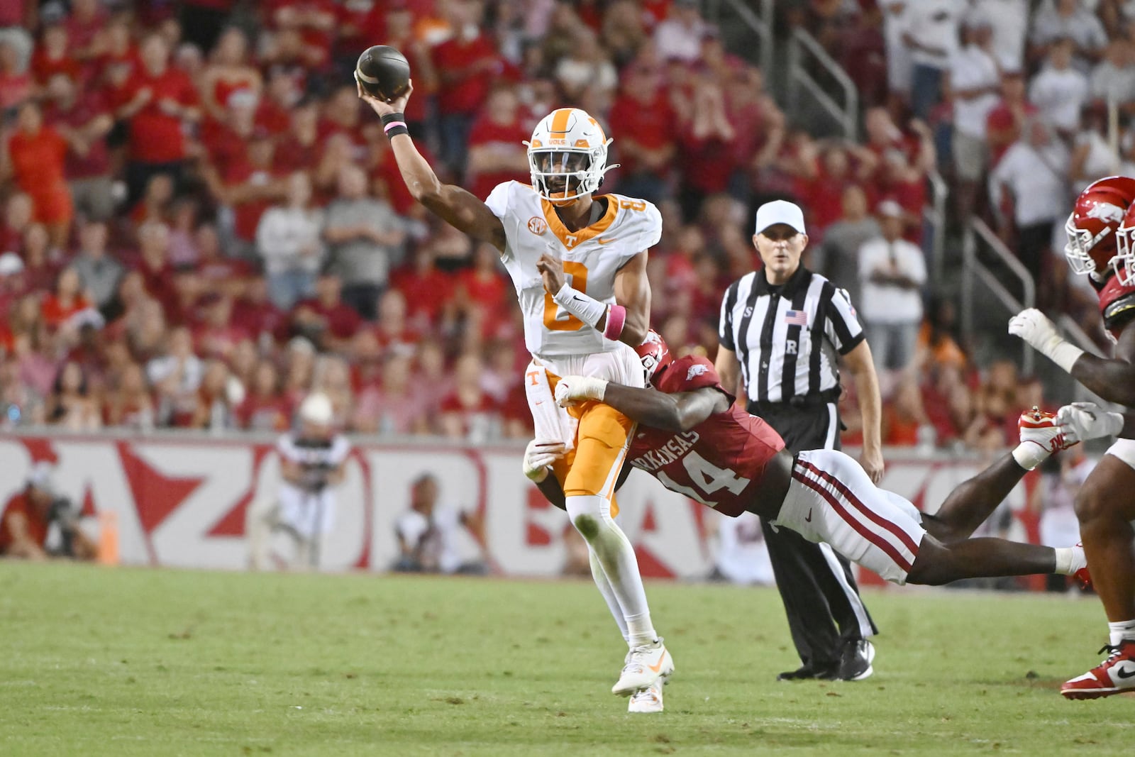 Tennessee quarterback Nico Iamaleava (8) throws under pressure from Arkansas linebacker Stephen Dix Jr. (14) during the first half of an NCAA college football game, Saturday, Oct. 5, 2024, in Fayetteville, Ark. (AP Photo/Michael Woods)