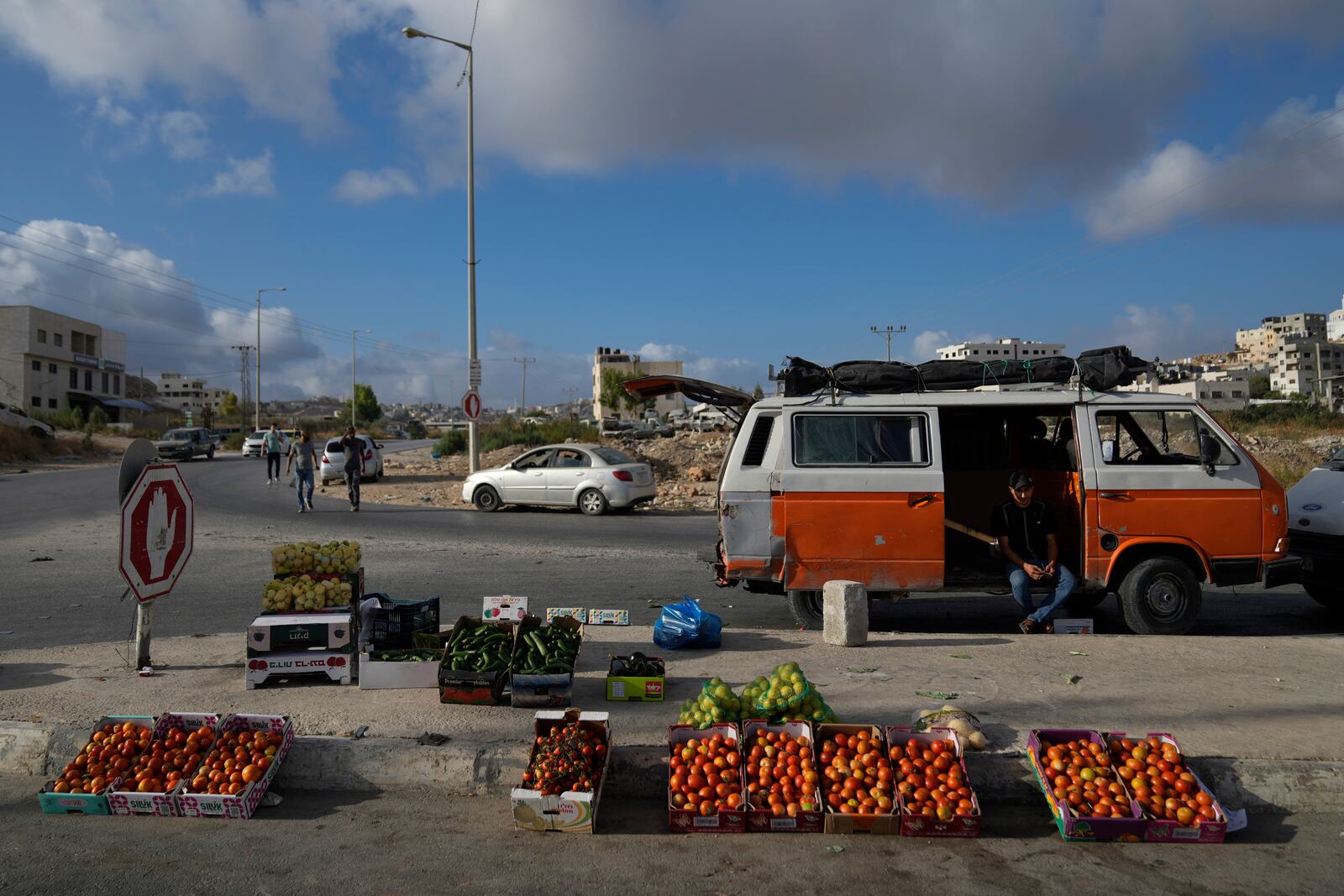 A Palestinian street vendor waits for customers while he displays vegetables for sale in the weekly market at the eastern outskirts of the West Bank city of Nablus Monday, Sept. 16, 2024. (AP Photo/Nasser Nasser)