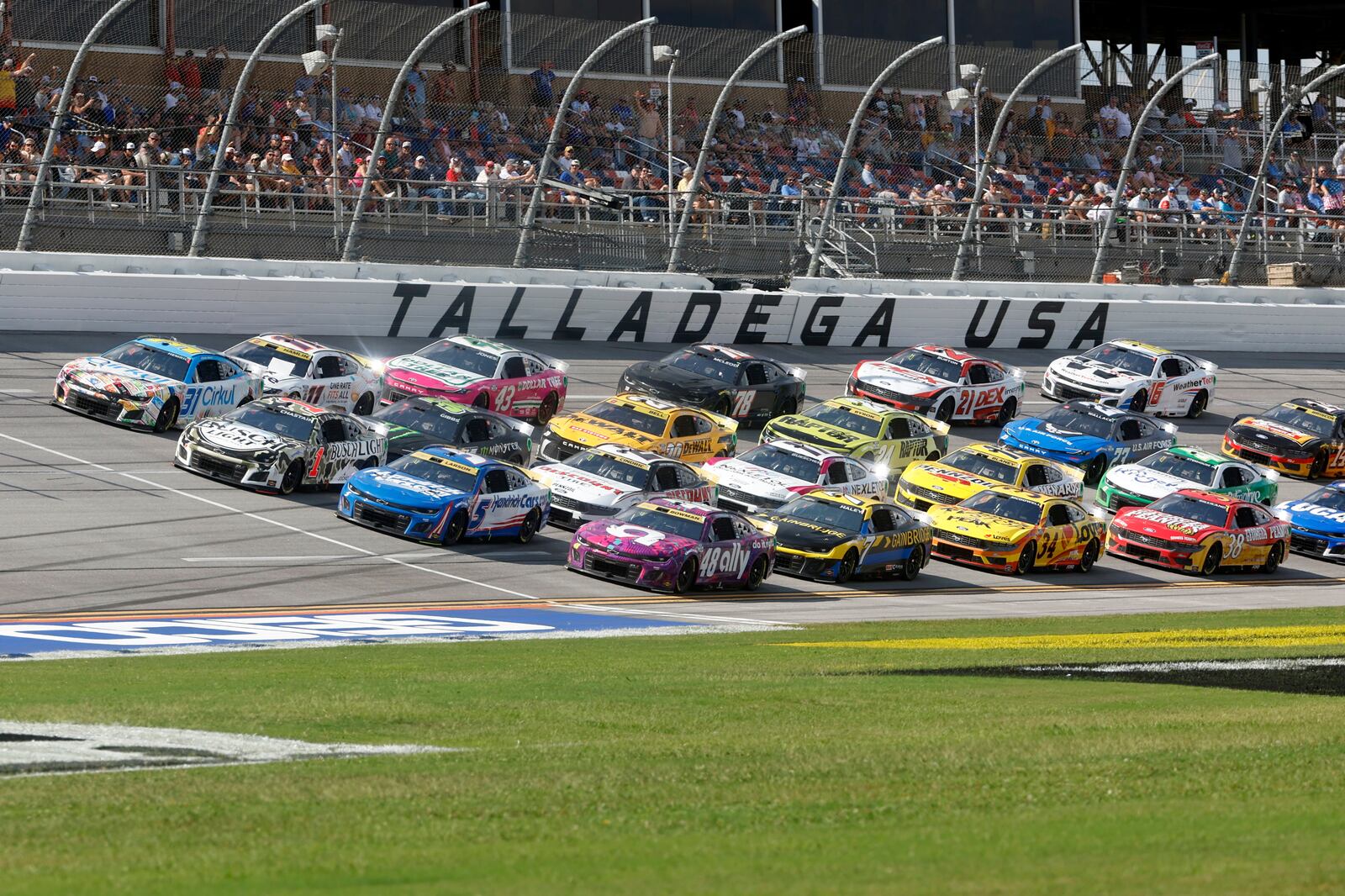 Drivers race down the front stretch four wide during a NASCAR Cup Series auto race at Talladega Superspeedway, Sunday, Oct. 6, 2024, in Talladega, Ala. (AP Photo/ Butch Dill)