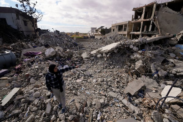 A woman inspects buildings destroyed in Israeli airstrikes in Baalbek, eastern Lebanon, Thursday, Nov. 28, 2024. (AP Photo/Hassan Ammar)