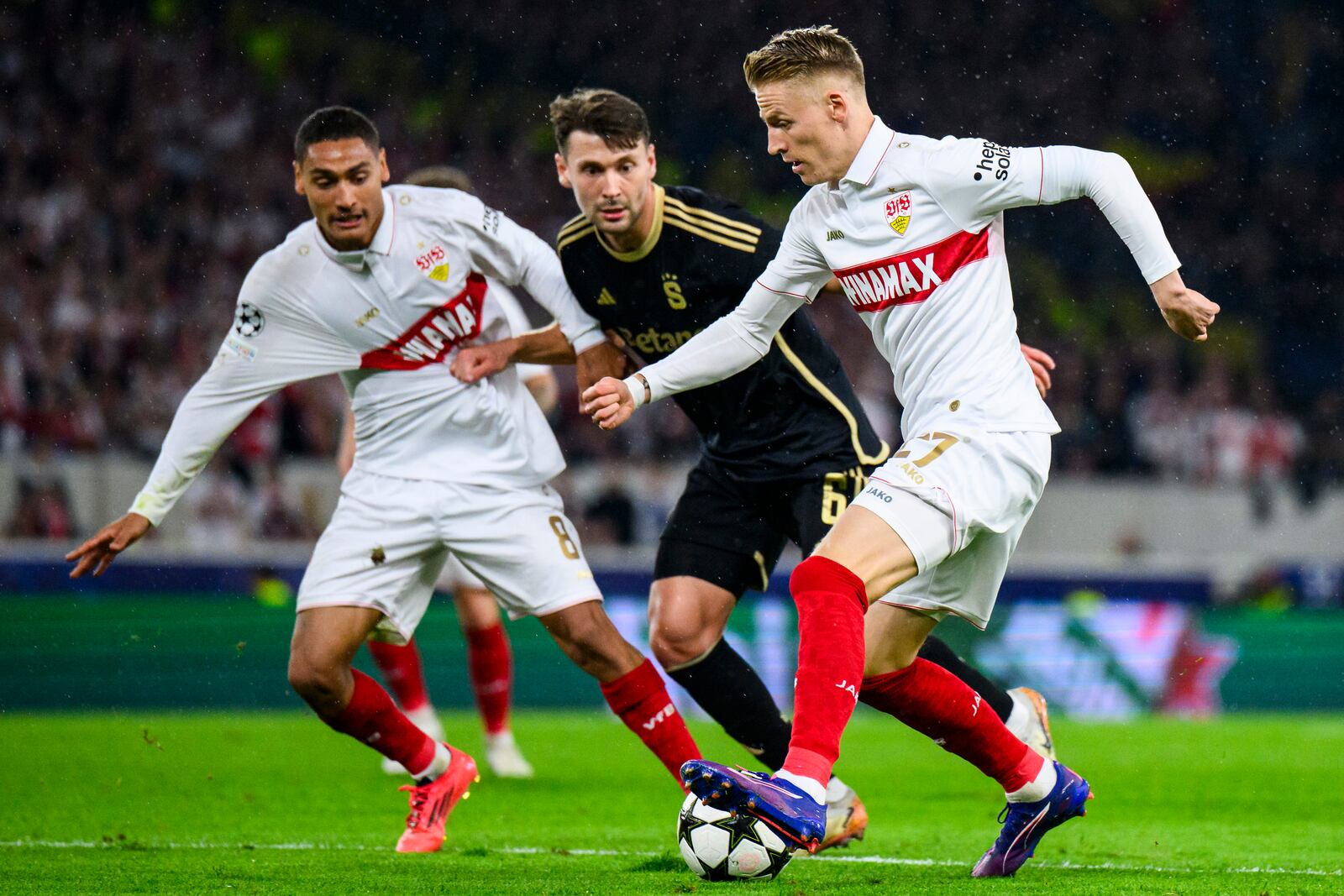 Stuttgart's Chris Führich, right, and Enzo Millot, left, challenge for the ball with Prague's Kaan Kairinen, center, during the Champions League opening phase soccer match between VfB Stuttgart and AC Sparta Praha in Stuttgart, Germany, Tuesday, Oct. 1, 2024. (Tom Weller/dpa via AP)