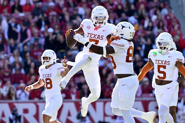 Texas defensive back Jahdae Barron (7) celebrates with teammate Barryn Sorrell (88) after making in interception against Arkansas during the first half of an NCAA college football game Saturday, Nov. 16, 2024, in Fayetteville, Ark. (AP Photo/Michael Woods)