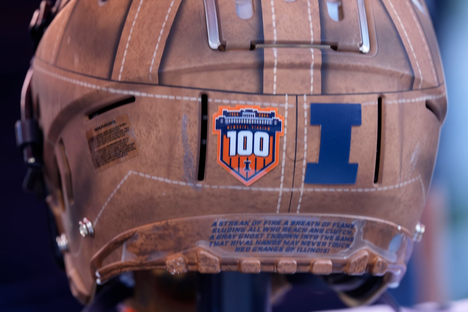 A throwback design of the 1924 Illinois football helmet is worn by players as part of the 100 anniversary celebration of Memorial Stadium during the first half of an NCAA college football game between Illinois and Michigan on Saturday, Oct. 19, 2024, in Champaign, Ill. (AP Photo/Charles Rex Arbogast)