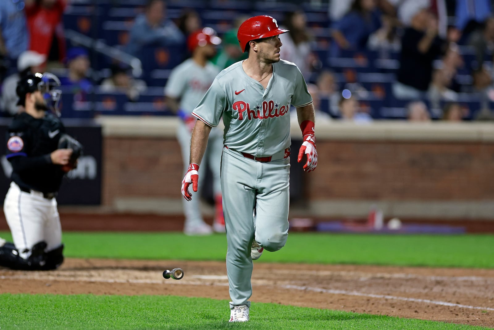 Philadelphia Phillies' J.T. Realmuto, right, watches his two-run home run during the eighth inning of a baseball game against the New York Mets, Friday, Sept. 20, 2024, in New York. (AP Photo/Adam Hunger)